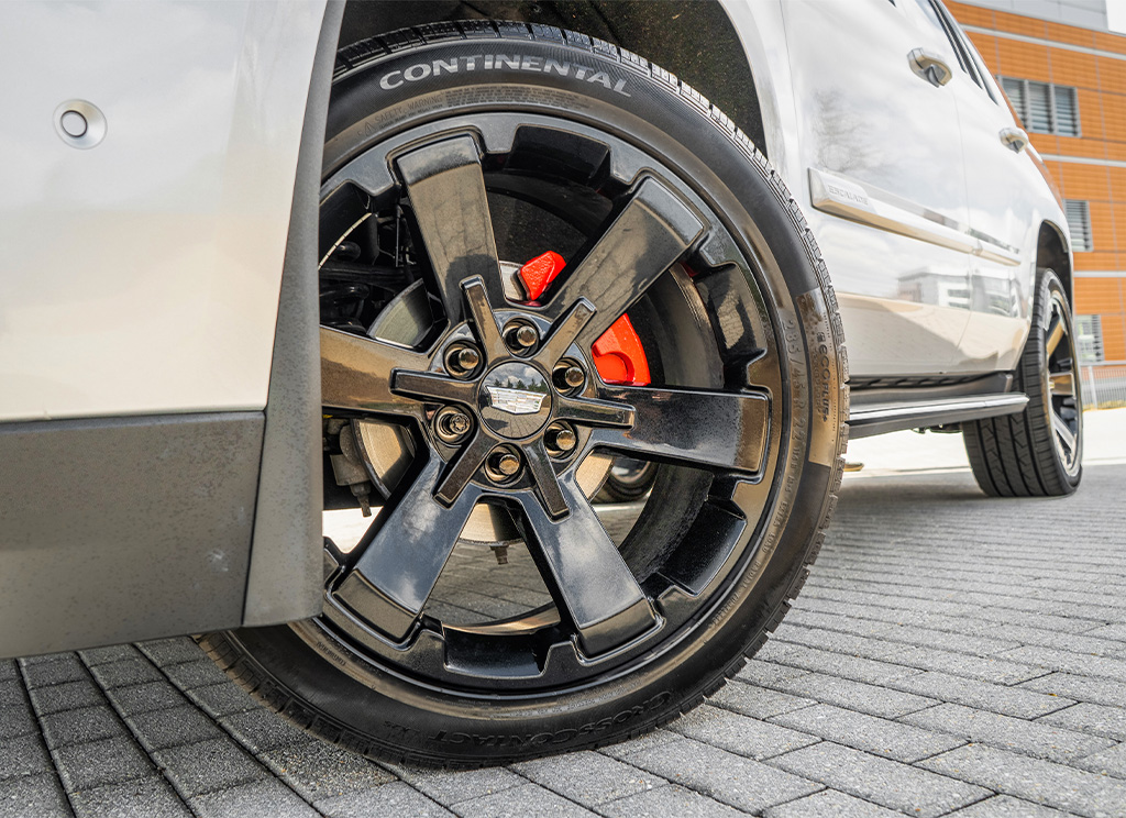 Black powder coat wheels and gloss red calipers on a Cadillac Escalade