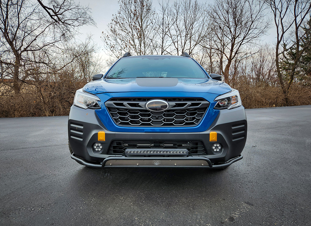 The grille of a blue Subaru Outback with an LP Aventure Bumper guard