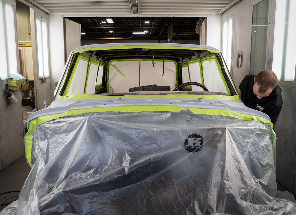 Taping covers on to the vehicle frame before painting.