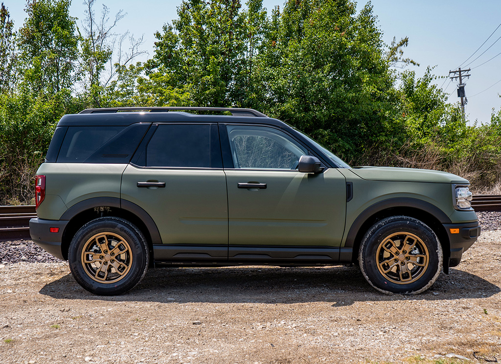 Side profile of a custom army green Bronco Sport SUV with bronze wheels