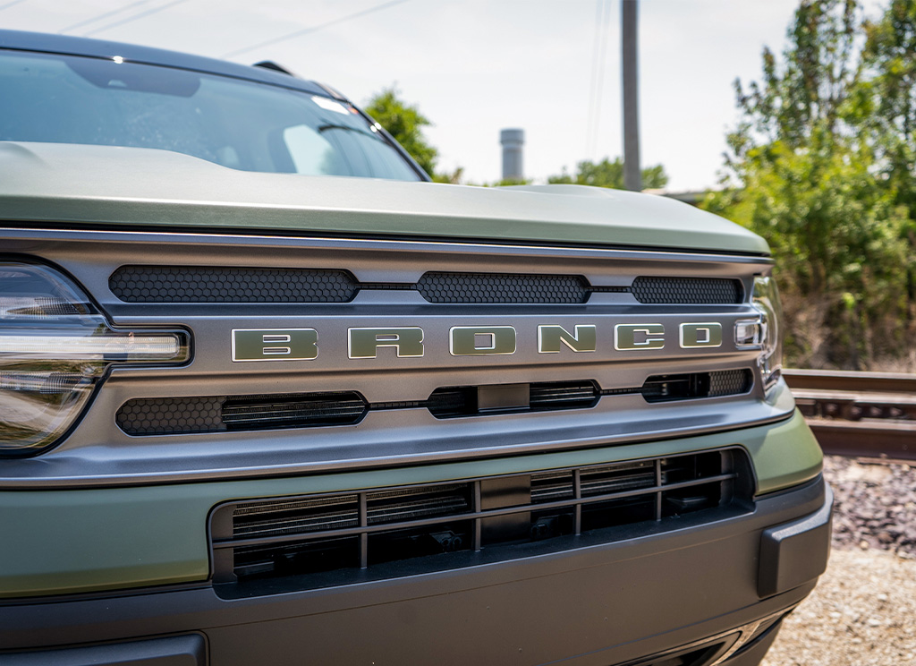 Green Bronco lettering on the grille of a Ford Bronco Sport