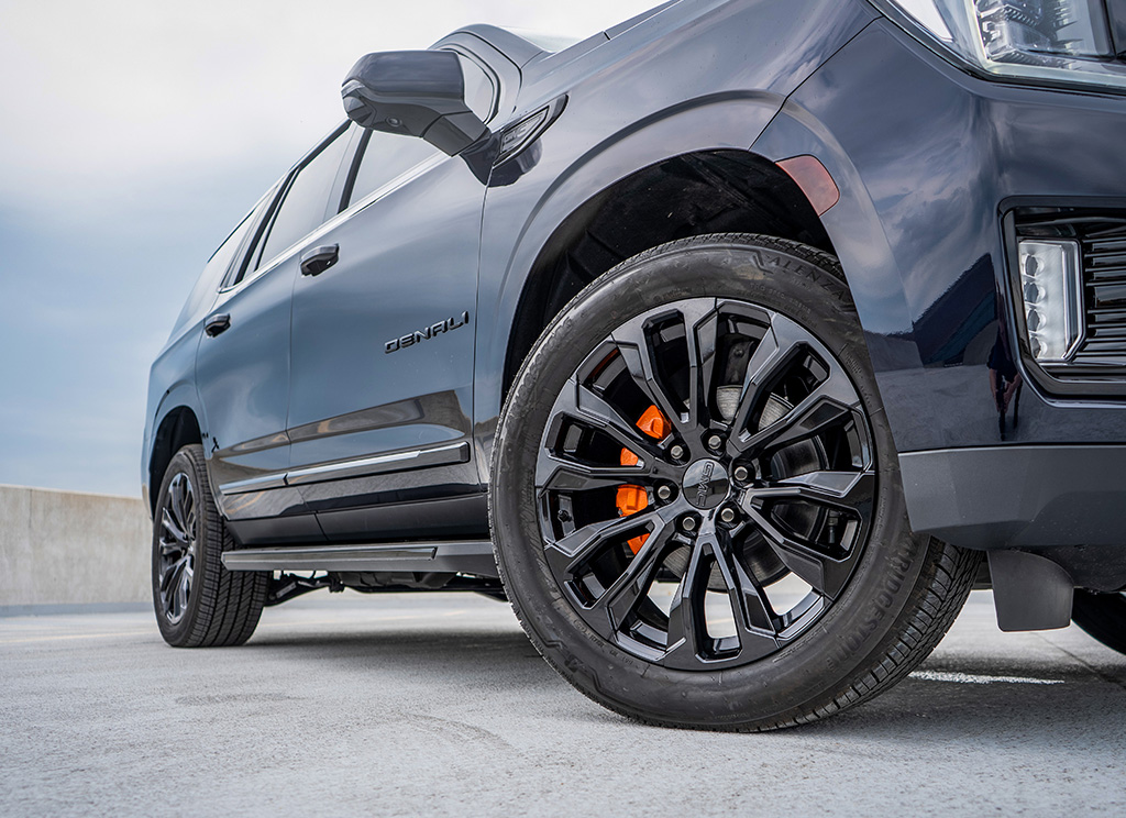 Black powder coated GMC wheels on a midnight blue Yukon Denali SUV.