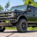 Custom satin black 2023 Ford Bronco offroad SUV with green accents.