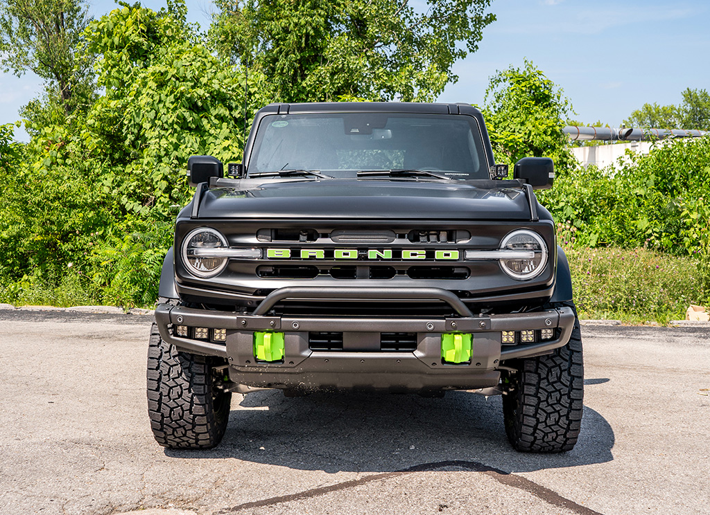 Grille of a custom 2023 Bronco with a bull bar and green accents.