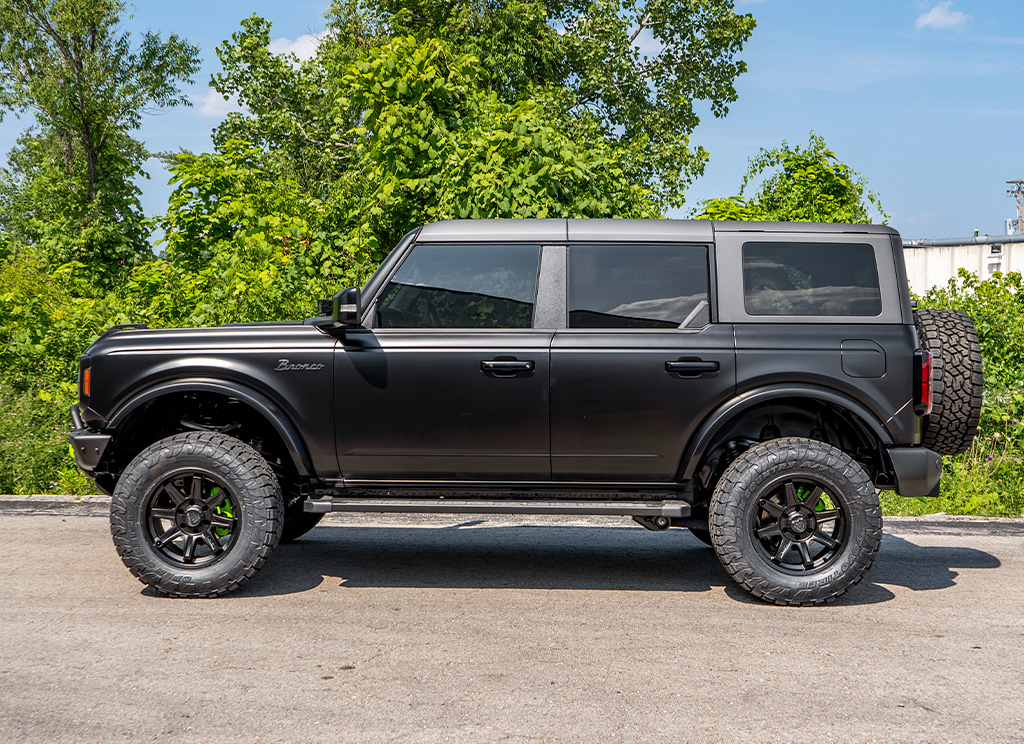 Profile view of a custom satin black 2023 Ford Bronco Offroad SUV.