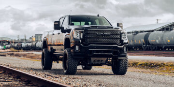 Chrome Delete 2023 GMC Sierra Denali truck in a train yard.