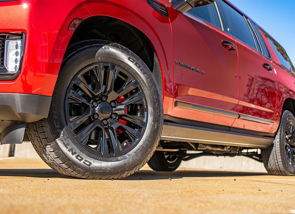 Black powder coated GMC Yukon stock wheels with red painted calipers.