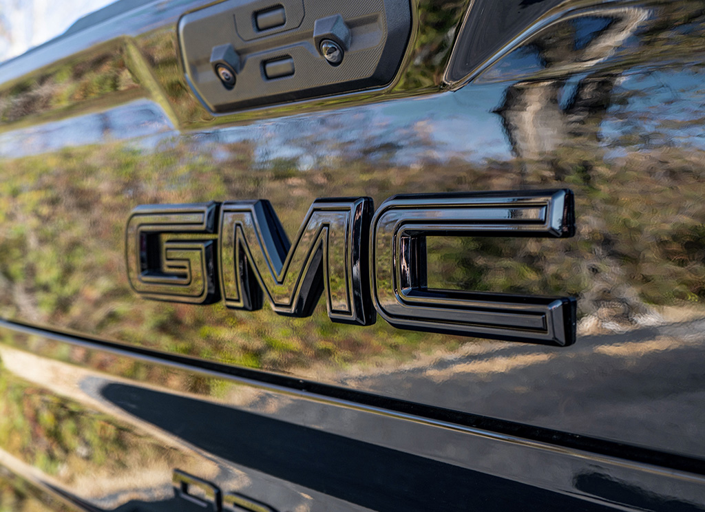 Full blackout GMC emblem on the tailgate of a Sierra 1500 truck.