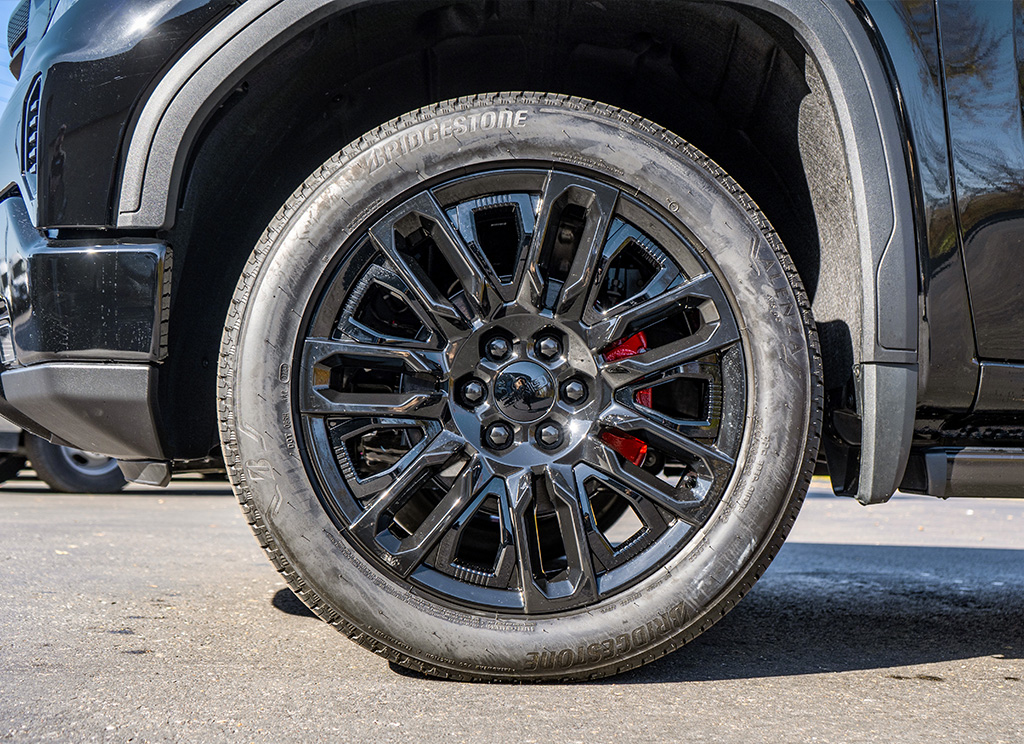 Black powder coated GMC Sierra wheels with red brake calipers.