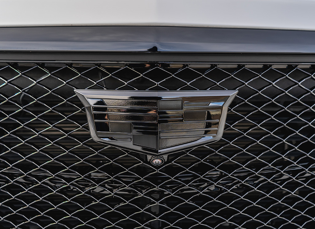 Blackout Cadillac emblem on the black mesh grille of an Escalade.