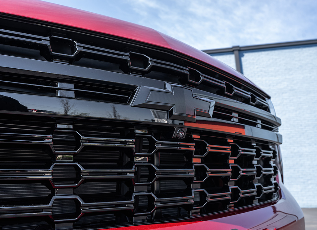 Close-up of a black Chevy Tahoe grille and blackout bowtie emblem.