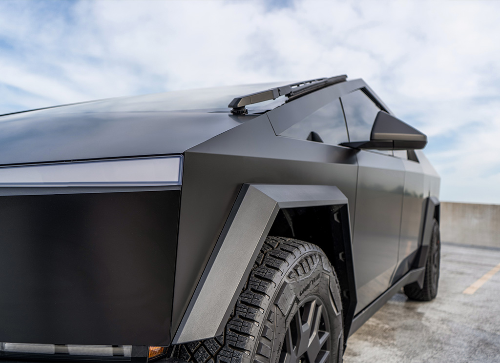 Close-up view of satin black vinyl wrap on a Tesla Cybertruck.