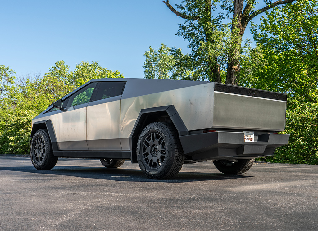 Rear view of a Tesla Cybertruck with a dirty stainless exterior.