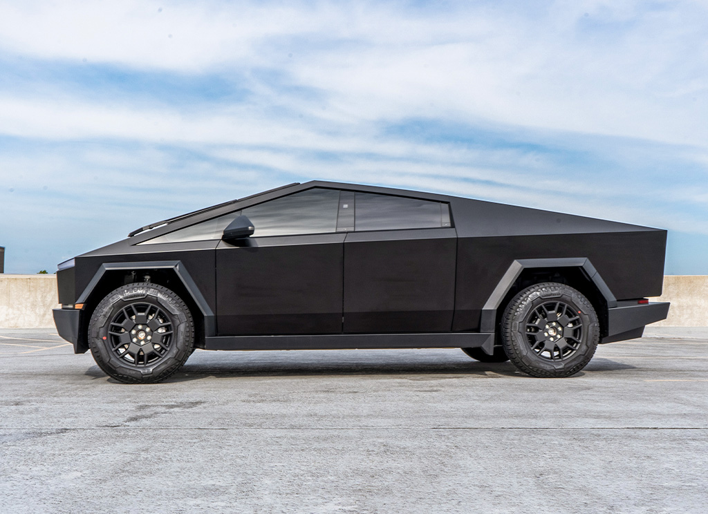 Side profile of a satin black Tesla Cybertruck with custom accessories.