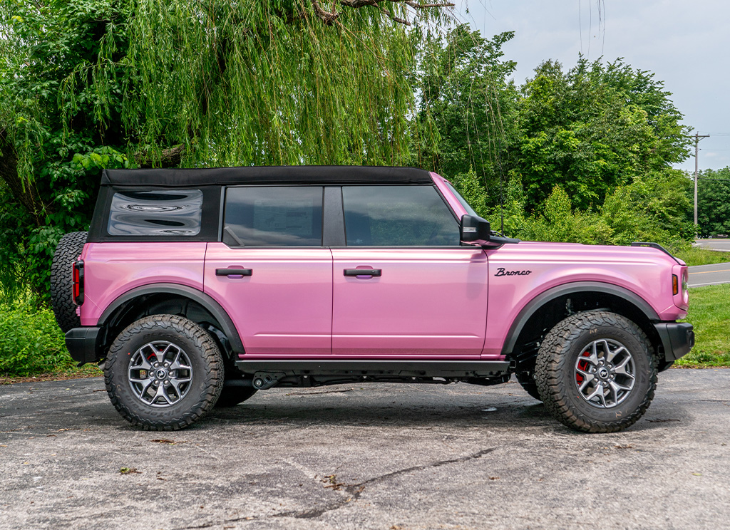 Profile view of a iridescent pink Ford Bronco SUV that has custom upgrades and accessories.