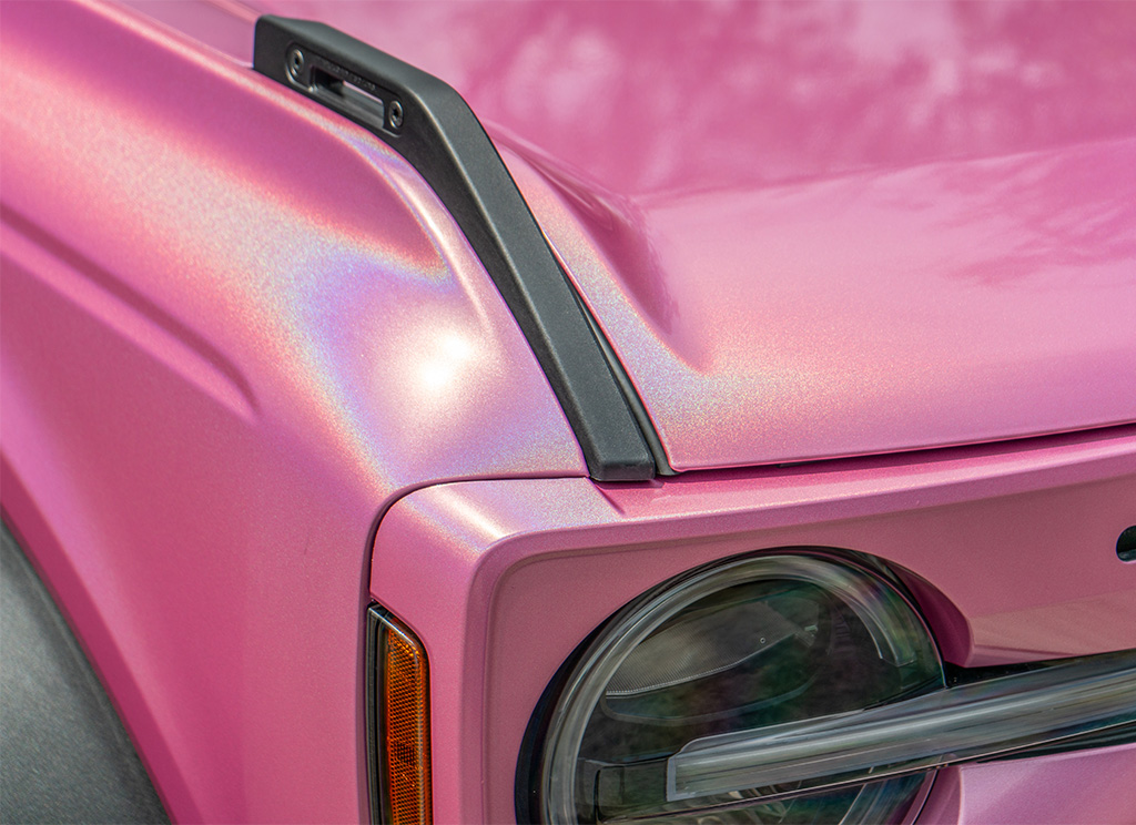 Close-up of the iridescent pink vinyl wrap from Aura films on a Ford Bronco hood and fender.