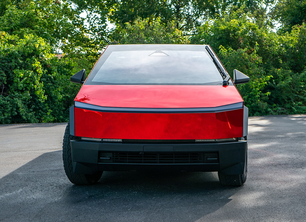 Front view of a tesla Cybertruck with a super chrome gloss red vinyl wrap.