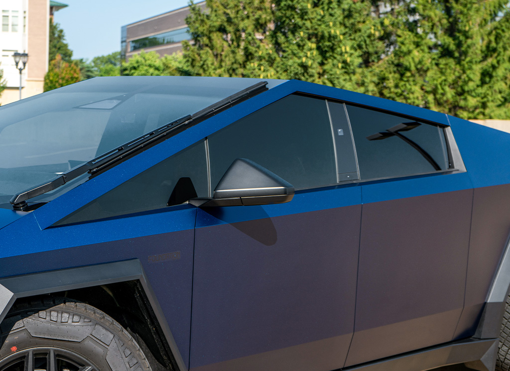 Close-up of window tint on a custom blue Cybertruck.