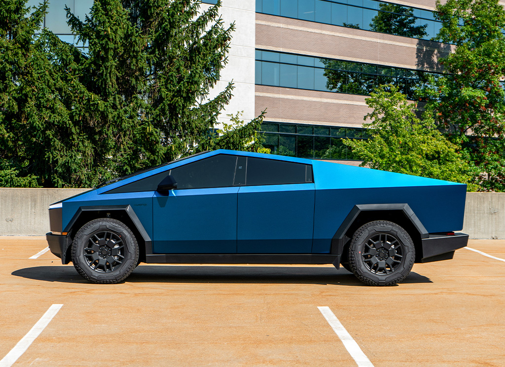 Side profile of a Tesla Cybertruck with a satin blue wrap.