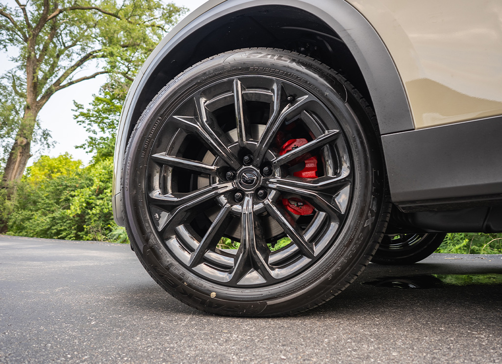 close-up of powder coated black Mazda CX-70 wheels and red painted brake calipers.