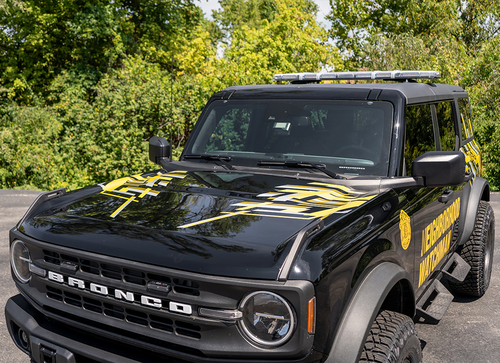 Abstract urban hood stripes on a custom black Ford Bronco security build.