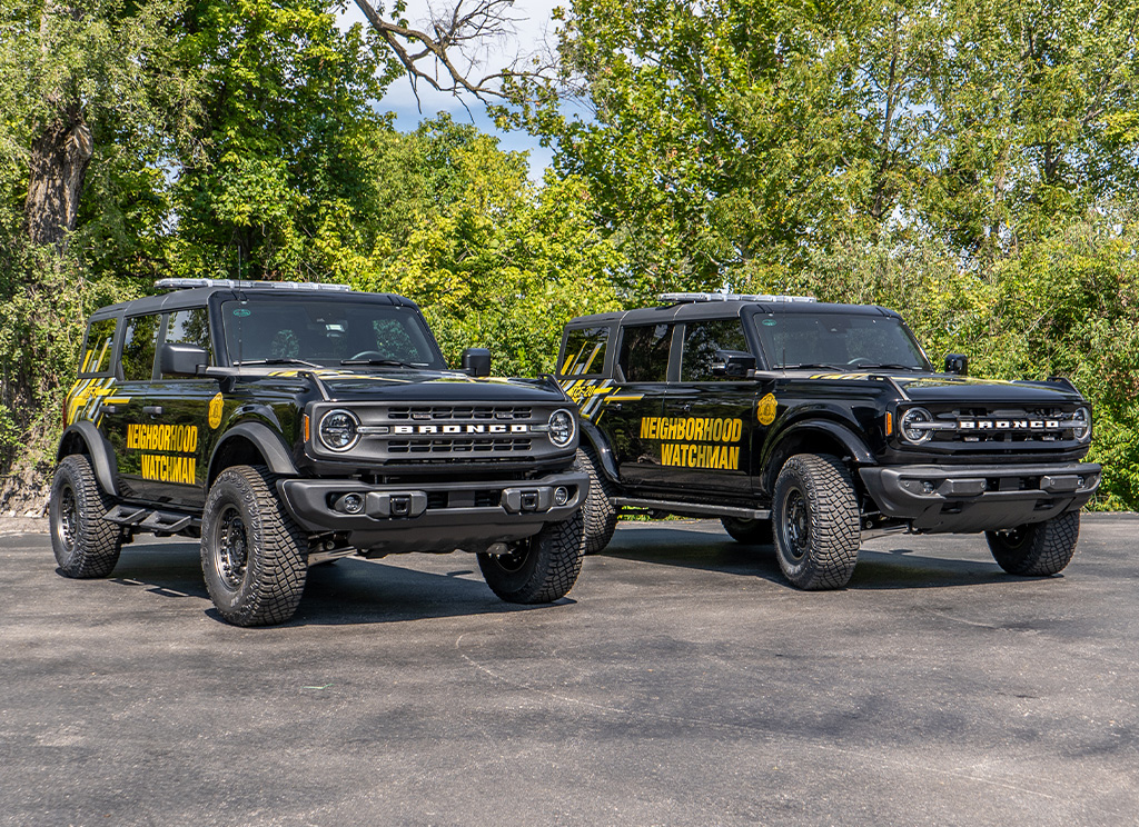 Lifted Ford Broncos side by side with custom graphics and offroad accessories.