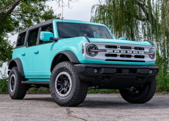 Custom teal blue Ford Bronco with a white grille and emblems.