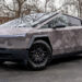 Full view of a Tesla Cybertruck with a gray camouflage printed vinyl wrap.