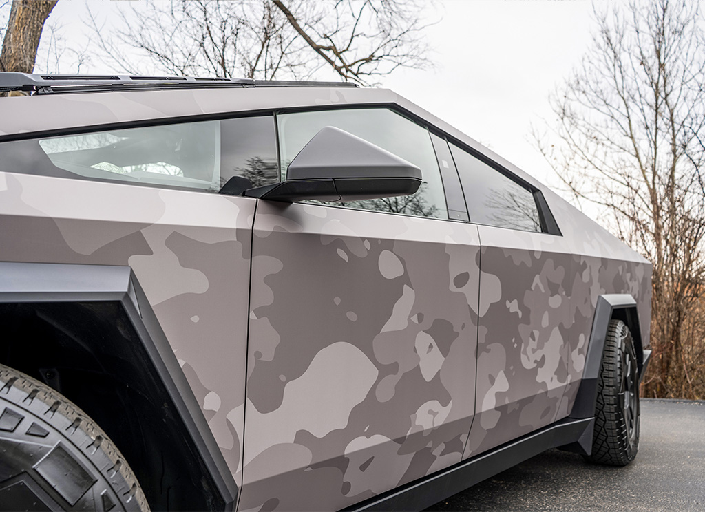 Close up of a gray camouflage printed vinyl wrap on a Tesla Cybertruck front driver side door.