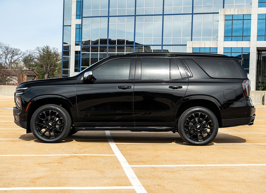 Side profile of a blackout 2025 Chevy Tahoe with chrome delete trim and tinted windows.
