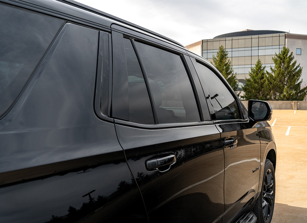 Blackout window molding and tinted windows on a 2025 Chevy Tahoe SUV.