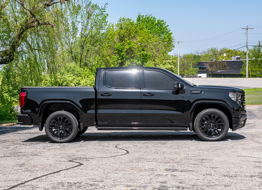Side profile of a blackout GMC Sierra 1500 Denali truck with chrome delete trim.