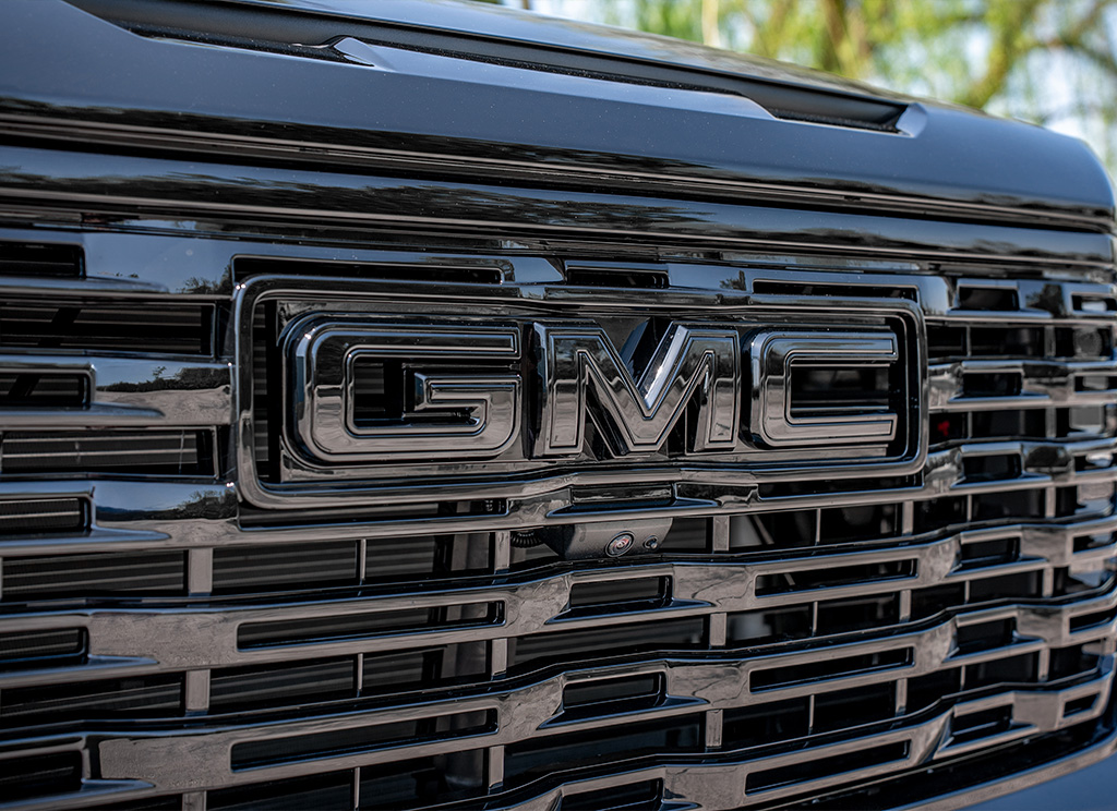 Black GMC front emblem on a gloss black Sierra 1500 grille.