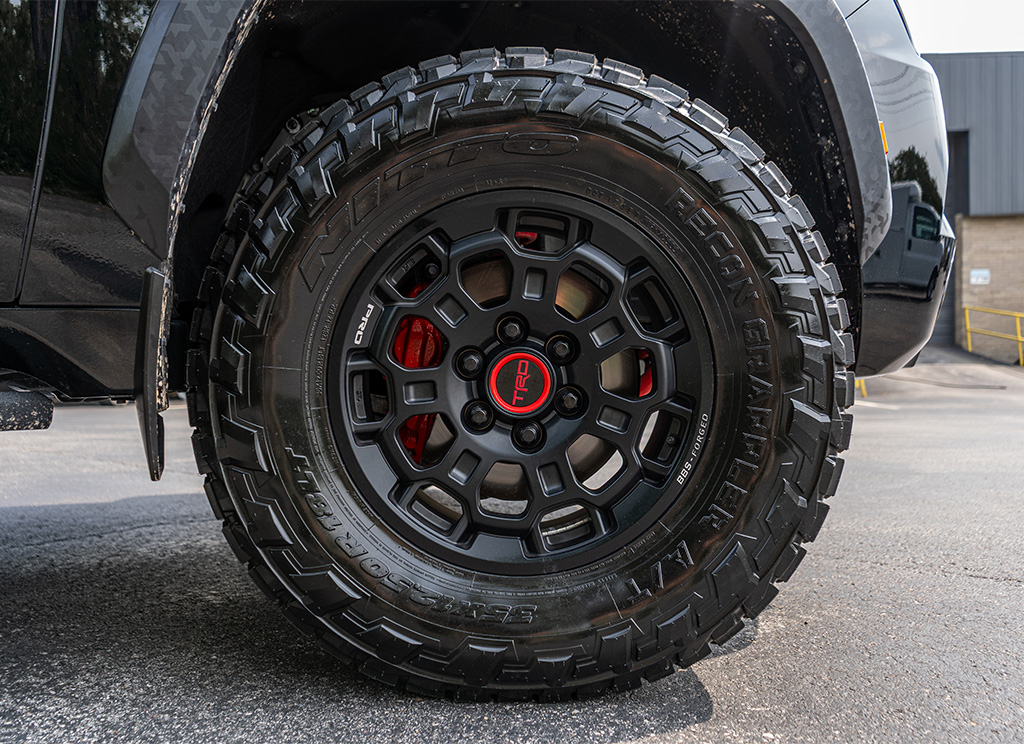 Red painted brake caliper behind Nitto Ridge Grappler tires and TRD Pro rims.