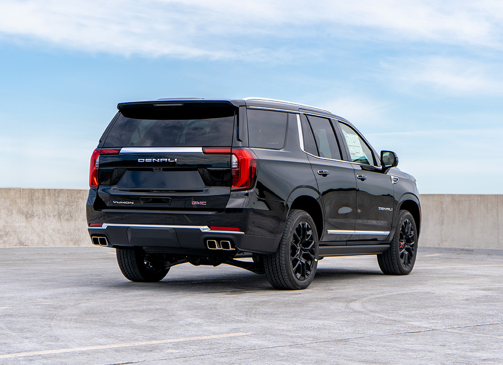 Full rear view of a black 2025 GMC Yukon Denali with factory chrome trim.
