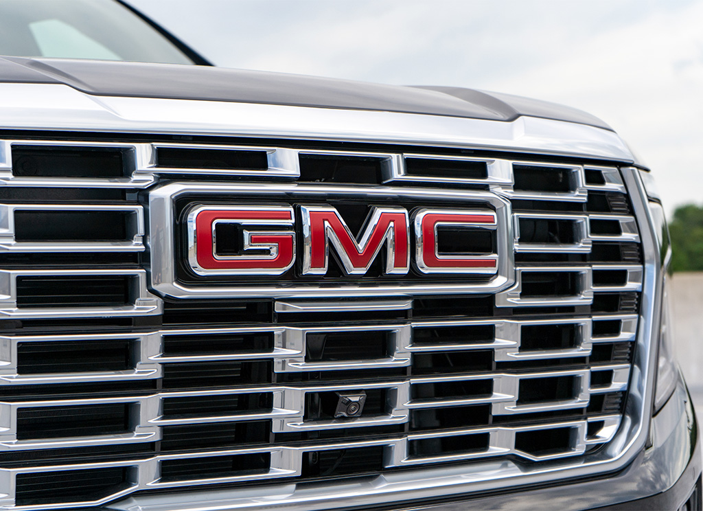 Close up of a factory chrome 2025 GMC Yukon Denali grille and GMC Emblem.
