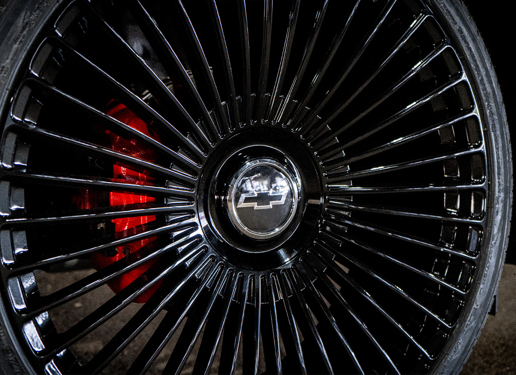 Red painted brake calipers behind gloss black Dolce Luxury Trento rims.