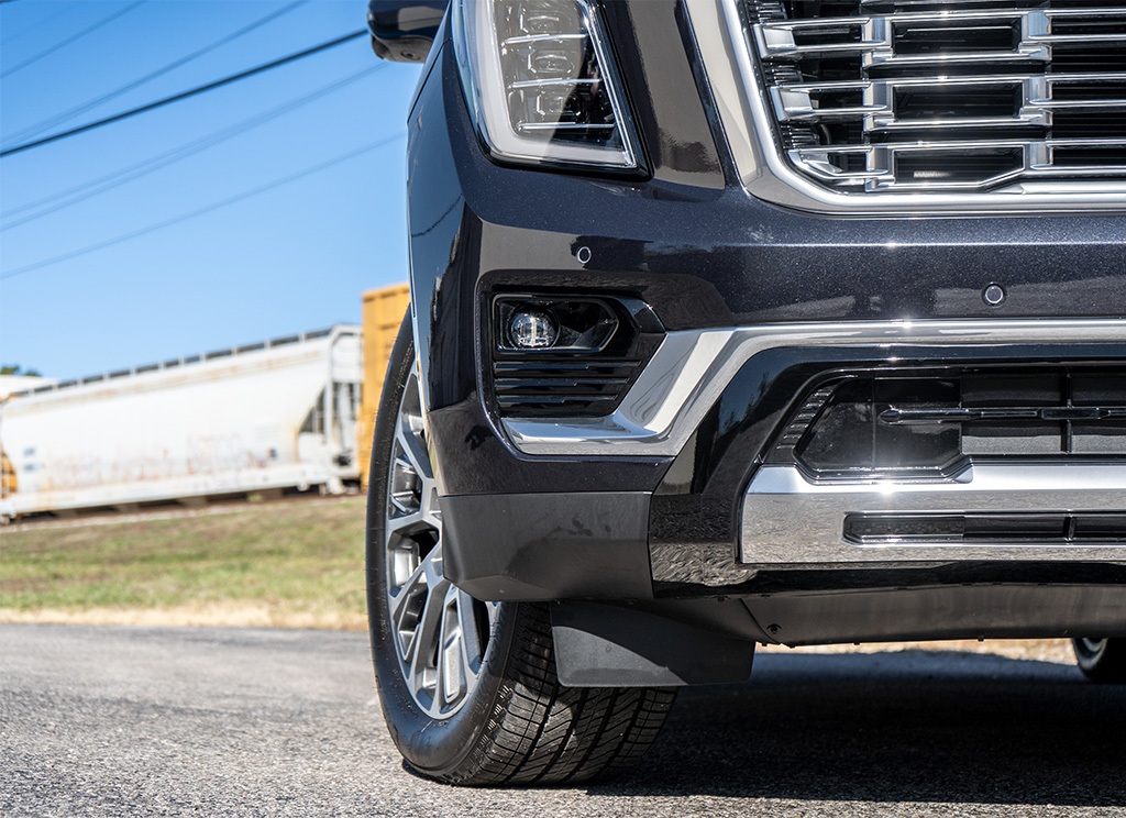 2026 GMC Yukon Denali factory original grille, fog light bezel molding, and front bumper trim.