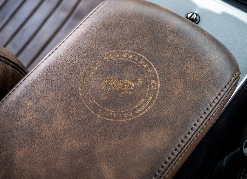 Close-up of custom laser engraved Bronco branding on the center counsel arm rest of a restored 1972 Ford Bronco.