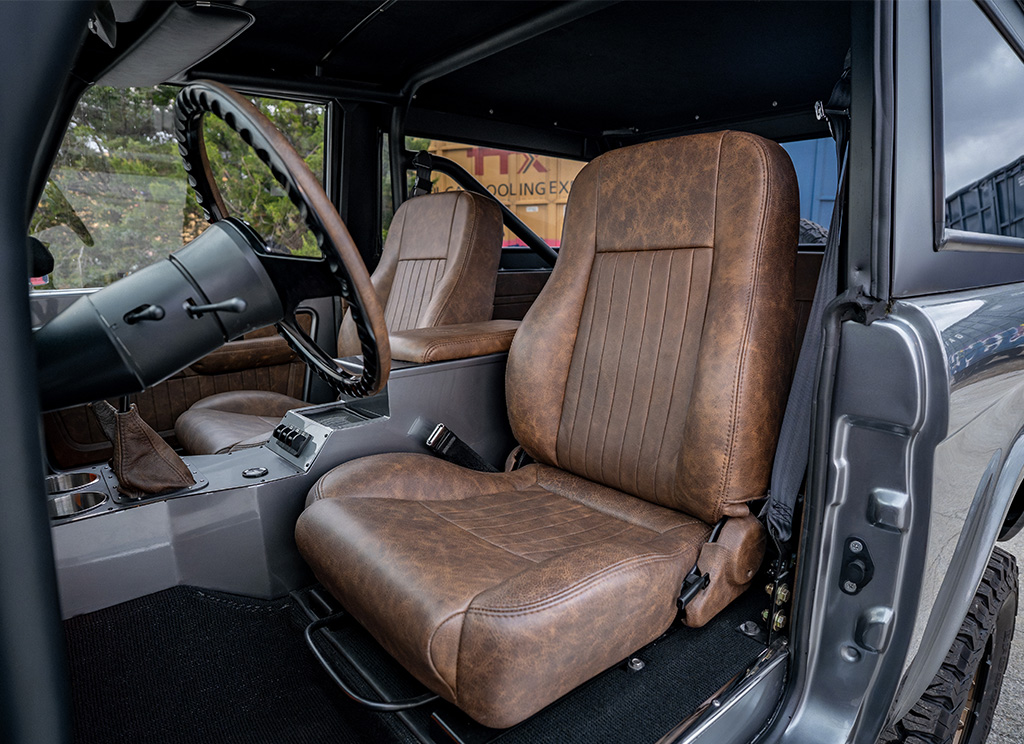 Custom dark brown coffee colored leather interior first row driver seat without head rests in a vintage restored 1971 Ford Bronco.