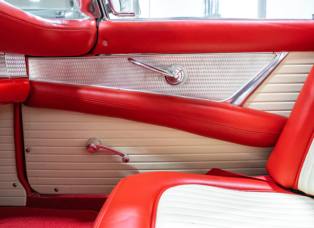 Restored interior red and white leather door panel of a 1956 Ford Thunderbird.