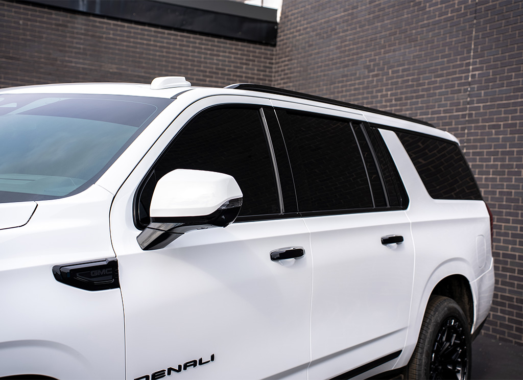 White 2026 GMC Yukon Denali with black window trim and tinted windows.
