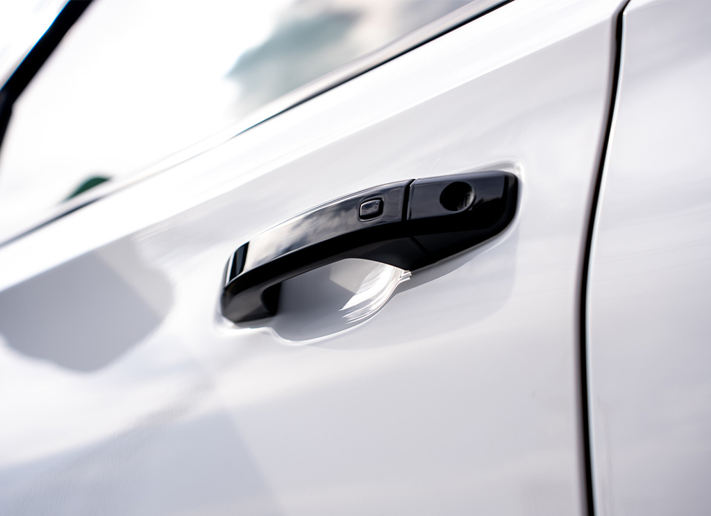 Close-up of black door handles on a white 2026 GMC Yukon Denali.