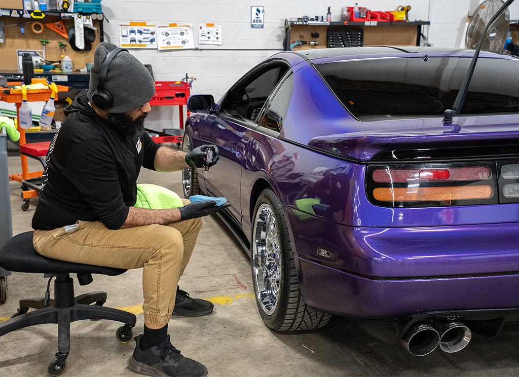 Technician installing ceramic coating on a purple 1991 Nissan 300ZX.