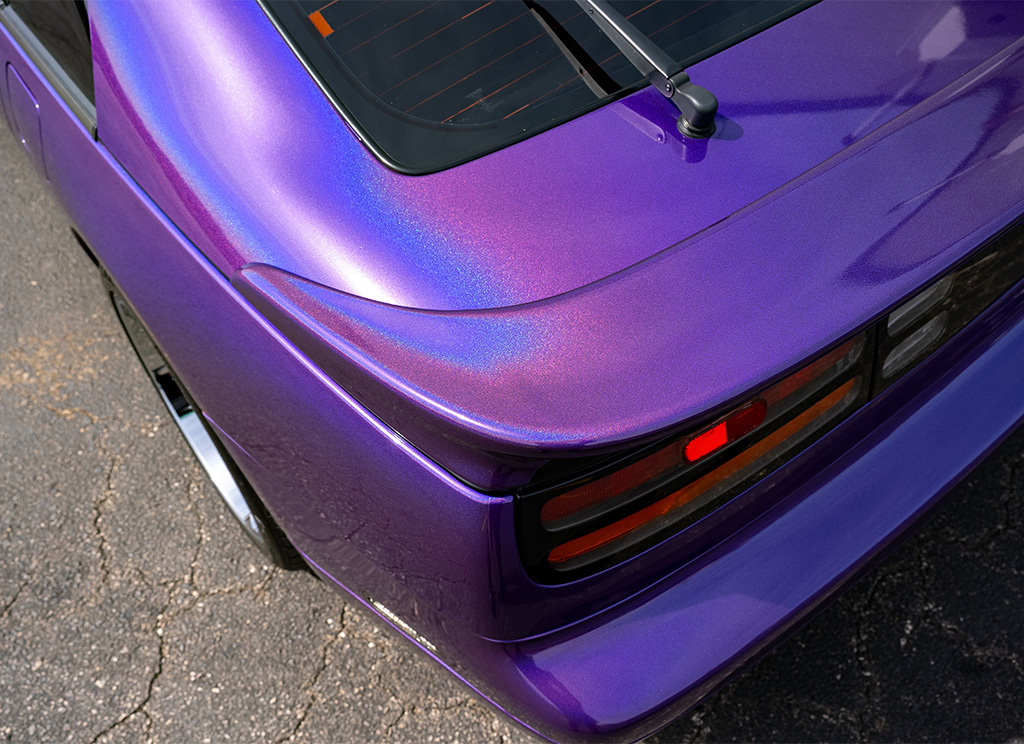 Close-up of a iridescent purple color flip wrap on the trunk spoiler of a Nissan 300ZX.