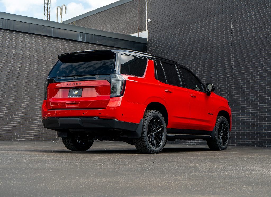 Rear hero view of a custom Victory Red 2026 Chevy Tahoe with black trim accents and accessories.