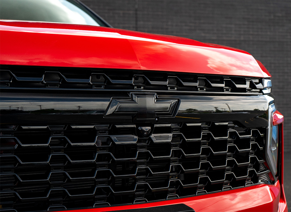 Close up of a black Chevy Bowtie emblem on a custom blackout 2026 Tahoe grille.
