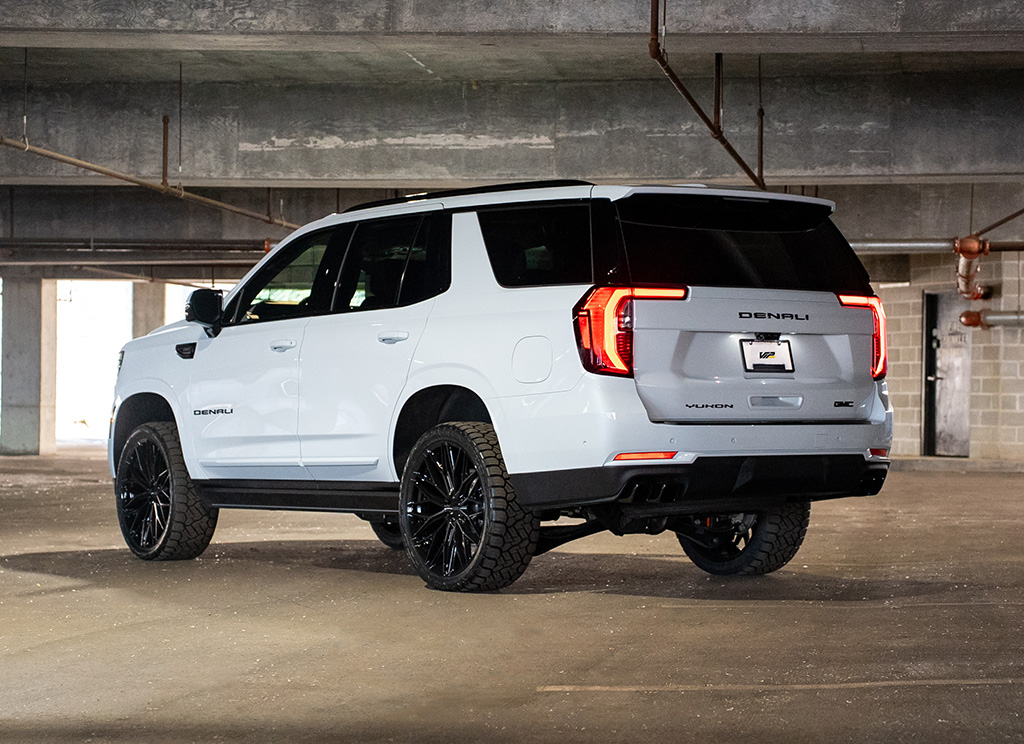 Rear hero angle view of a White Frost 2026 GMC Yukon Denali with blackout chrome delete trim.