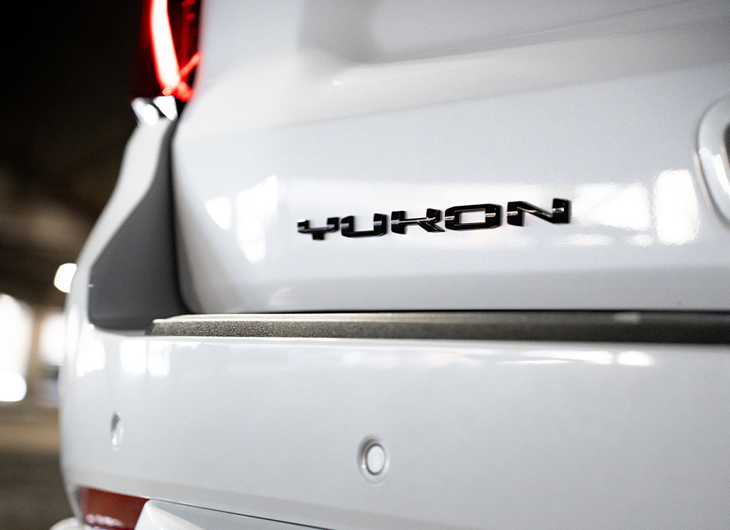 Close-up of a black Yukon nameplate on the tailgate of a 2026 GMC Yukon Denali.