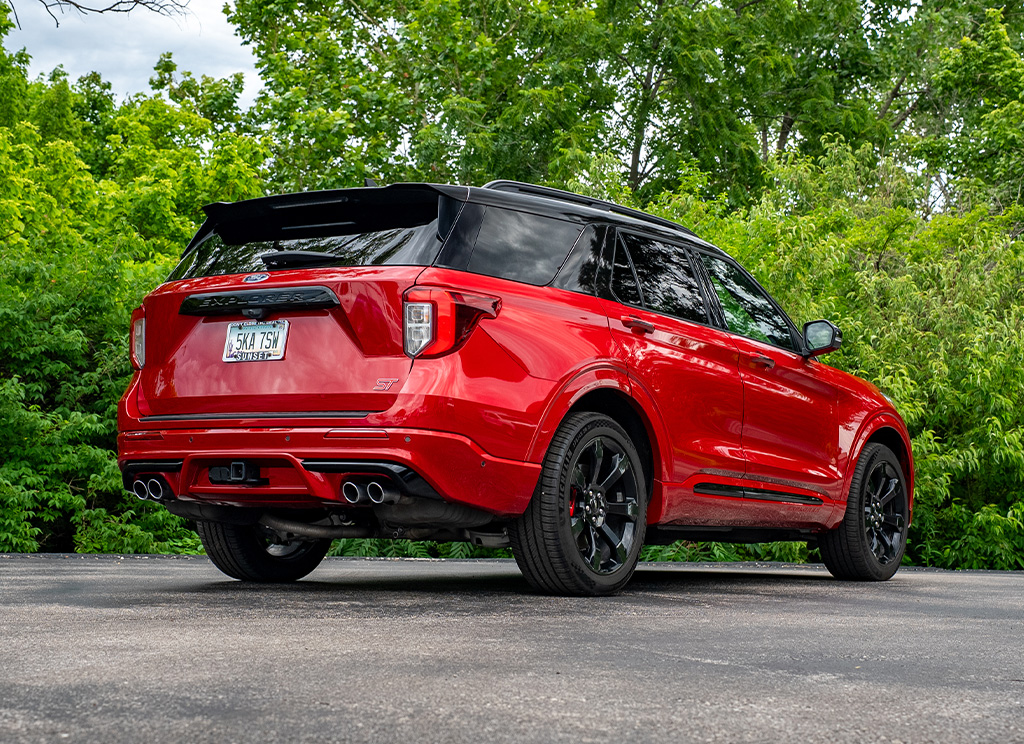 Rear angle view of a 2022 Rapid Red Ford Explorer with color matched rear bumper and bodyside cladding.